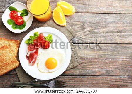Bacon and eggs on rustic wooden planks background