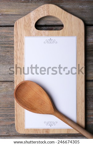 Cutting board with menu sheet of paper on rustic wooden planks background