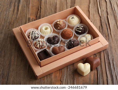 Delicious chocolate candies in gift box on table close-up