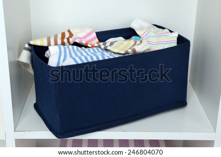 Different socks in textile box on closet background
