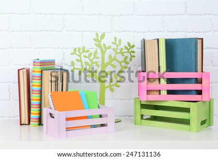 Many books in crates on brick wall background