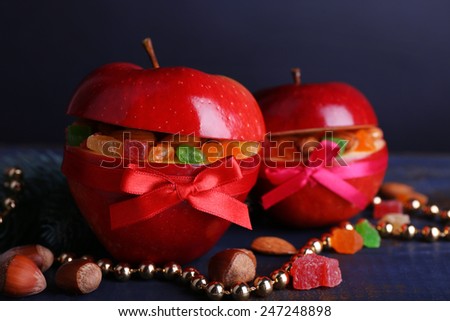 Red apples stuffed with dried fruits on color wooden table and dark background