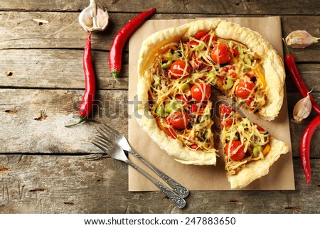 Vegetable pie with paprika, tomatoes and cheese on wooden background