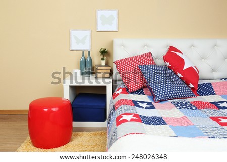 Modern colorful bedroom interior with bed and nightstand, with design details on light wall background