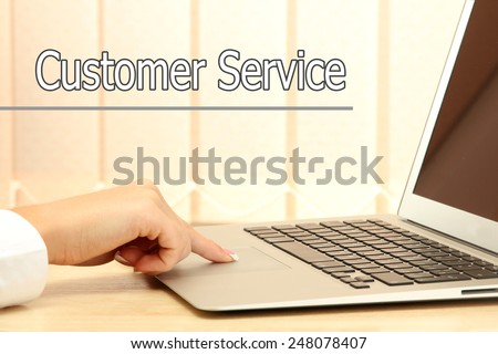 Laptop in office and Customer Service text on background