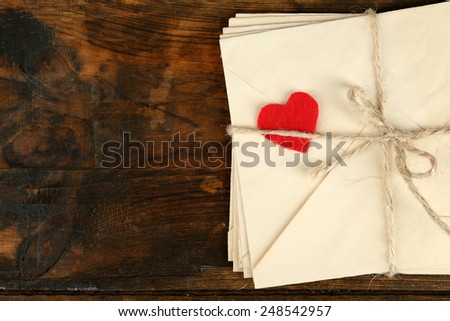 Stack of love letters on rustic wooden planks background