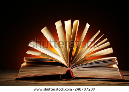Open book over dark colorful background