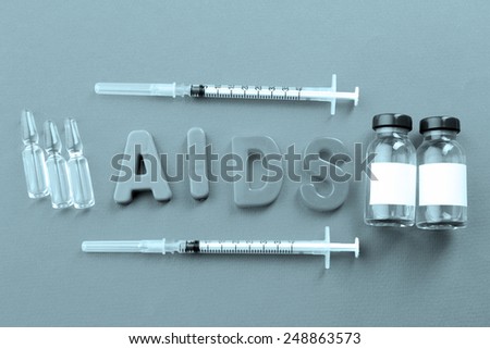 Medicines with word Aids on pink background