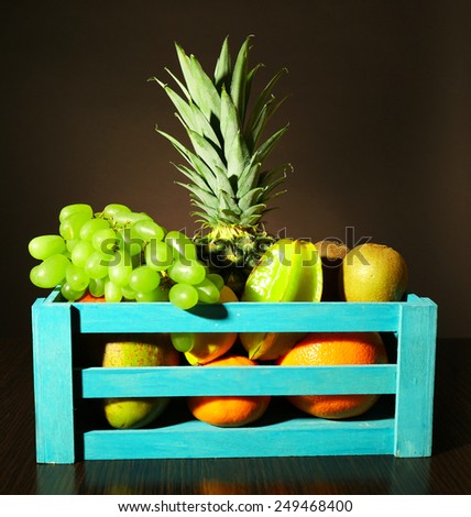 Assortment of fruits in box on dark background
