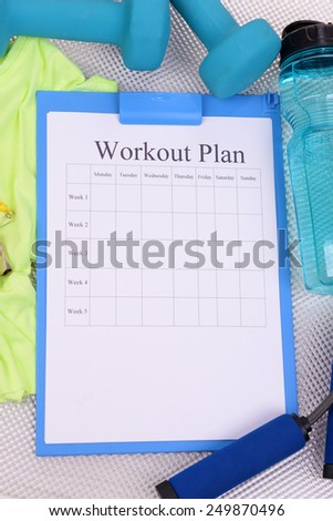 Workout plan and sports equipment top view close-up