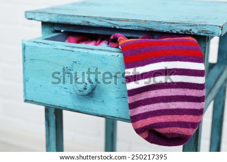 Socks in color drawer on white brick wall background