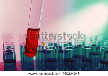 Test tube filled with red liquid on background of other tubes, close-up
