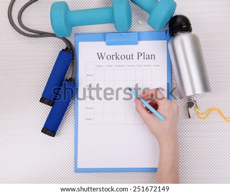 Sports trainer amounts to workout plan close-up