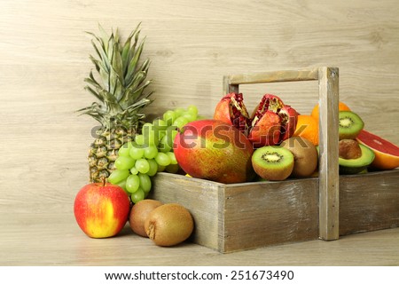 Assortment of exotic fruits in box on wooden background