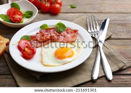 Bacon and eggs on rustic wooden planks background