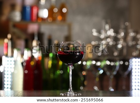 Glass of red wine with bar on background
