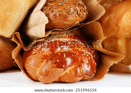 Fresh bread in paper bags on white table, macro view