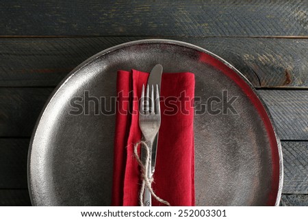 Silverware tied with rope on red napkin and metal tray background