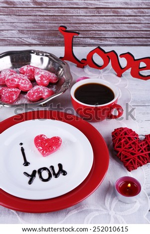 Cookie in form of heart on plate with inscription I Love You on color wooden table background