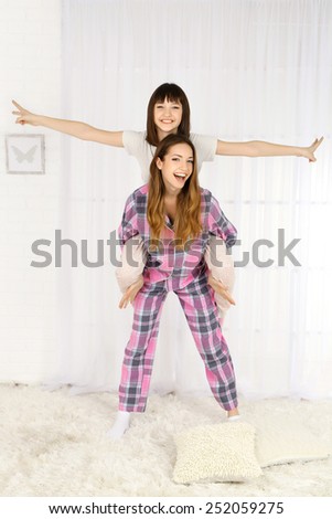 Two girls in pajamas on light background