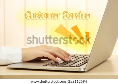 Female hands typing on laptop and Customer Service text on background