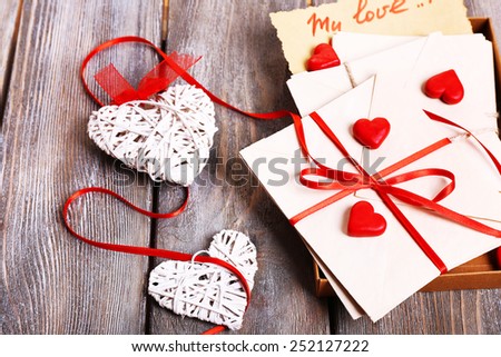 Love letters and hearts on wooden background