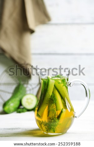 Glass with fresh organic cucumber water on wooden table