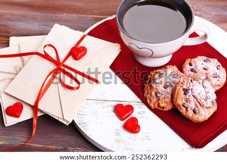 Love letters with coffee and cookies on wooden background