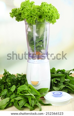Blender with fresh vegetables on kitchen table