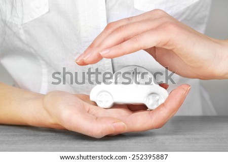 Hands and toy car. Protection of car concept