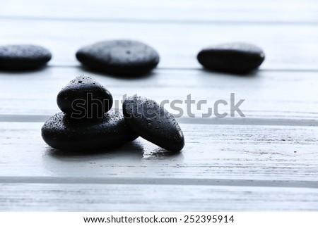 Spa stones with water drops on wooden background