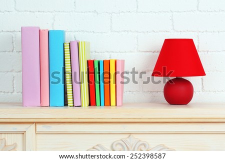 Books on shelf on wall background