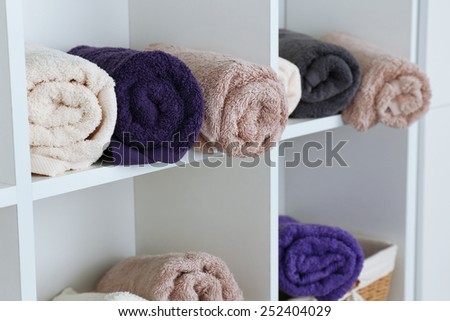 Rolled towels on shelf of rack background