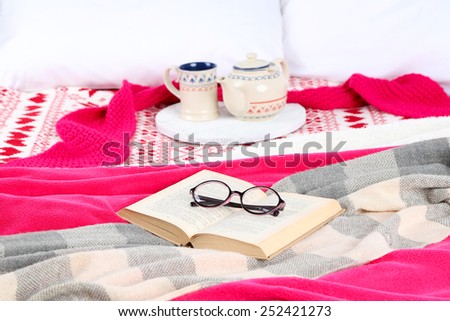 Book and tea on bed close-up