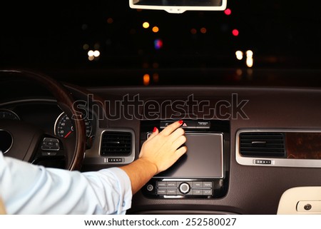 Woman driving his modern car at night in city, close-up