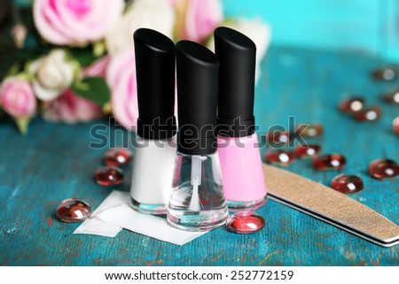 French manicure set with white tip polish, dividers and top coat shine applicator for nails on color wooden background