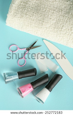 French manicure set with white tip polish, and top coat shine applicator for nails on color background