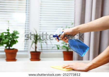 Male hands with sprayer and rag wash windowsill on window background