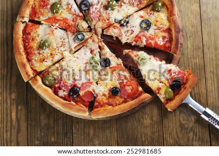 Pizza with cheese and pizza paddle on wooden table background
