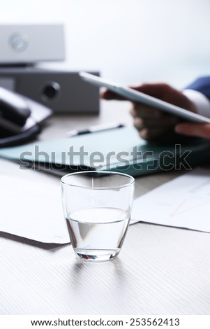 Businessman working at table in office on white blurred background