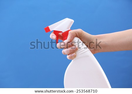 Male hand with sprayer on colorful background