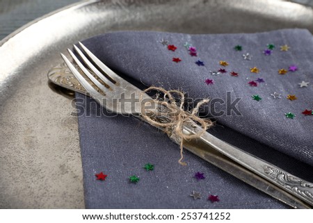 Silverware tied with rope on napkin and metal tray background