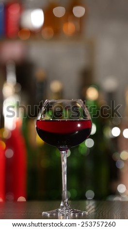 Glass of red wine with bar on background