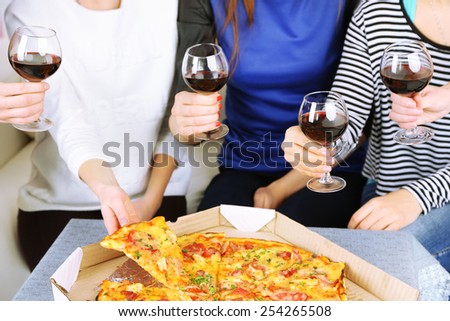Friends hands with glasses of wine and pizza, close up