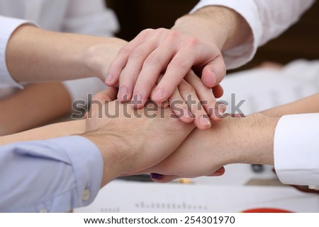 United hands of business team on workspace background