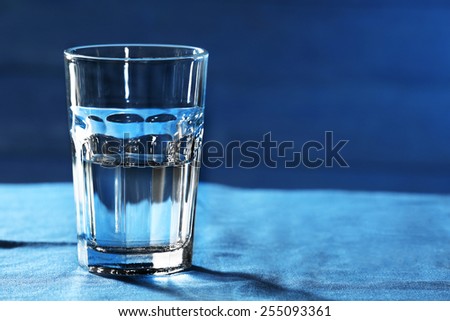 Glass of water on table on wooden background