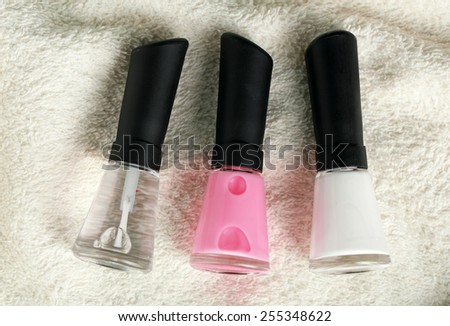 French manicure set with white tip polish, and top coat shine applicator for nails on towel background