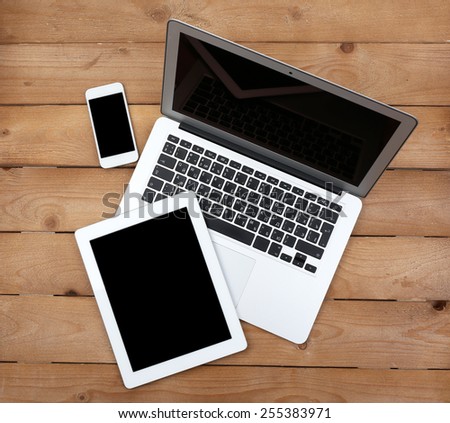 Open notebook, digital tablet and smart phone on wooden background, top view