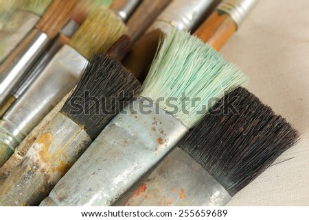 Different paintbrushes on fabric background