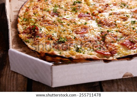 Tasty pizza in box on wooden background